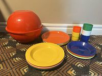 Orange spherical container with plates and stacking cups, showing full set spread out.