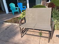 Front angle photo of the two-seat outdoor glider rocker bench showing overall condition and materials.