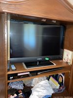 Front view of the 32-inch Insignia flatscreen TV in a wooden shelf.
