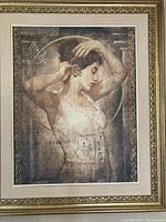 Full view of framed wall art depicting a woman in corset with neutral tones and gold frame