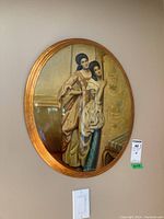 Oval framed signed dimensional wall art depicting two women in traditional dress with gold accents and background, photo taken to show detailed artwork and condition.