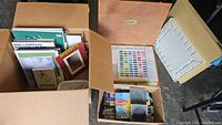 Overview of cardboard box with art books, wooden pastel case open with visible pastels and palette tray