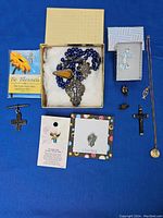 Overview of religious jewelry assortment on blue fabric