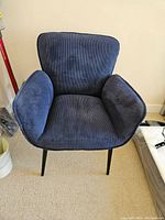 Front view of the blue corduroy occasional chair showing padded seat, back and armrests with vertical ribbed texture fabric.