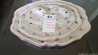 Set of three oval trays/platters stacked with two ceramic candle holders, displaying colorful Petite Fleur floral pattern and red edge accents.