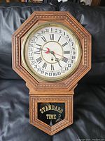Full view of vintage Admiral wall clock showing wooden octagonal case with intricate carved border, glass face and lower panel inscribed 'STANDARD TIME'.