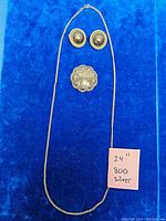 Full set on blue background showing chain, brooch, and earrings with note displaying '24 inch 800 silver'
