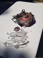 Copper light fixture base with decorative leaf accents and pile of clear glass crystal prisms and rods.