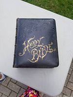 Black hardcover Bible with embossed texture and gold lettering 'Holy Bible' on front cover.