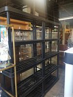 Three black plastic shelving units assembled in situ