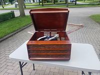 Front view of the closed wooden console record player, showing vintage mid-century style wood finish.