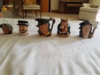 Five small Toby jugs in a row, showing full front detail of each character.