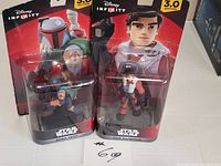 Two Disney Infinity 3.0 Edition Star Wars action figures in original packaging, Boba Fett and Poe Dameron.