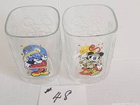 Pair of clear rectangular drinking glasses with colorful Mickey Mouse Disney images from McDonald's.