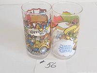 Two 1981 Jim Henson Muppet collectible glasses side by side. One with Happiness Hotel design, the other with The Great Muppet Caper design.