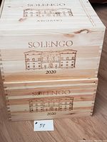 Two stacked wooden wine boxes branded Solengo with engraving of building and text 'Arciano' and '2020'. Natural wood color with dovetail joints.