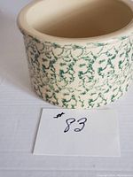 Side view of the ceramic Robinson Ransbottom spatter ware jar showing its green spattered textured pattern on a cream base.