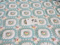 Close view showing multi-color crochet squares with pink roses and open lattice design