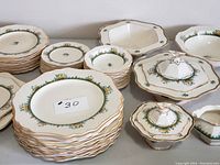 Photo showing full china set arranged on a surface including plates, casseroles, lids, platters, and smaller dishes.