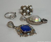 Photo shows both rings and both pendants arranged on a surface, highlighting pearl ring, loop ring, blue stone pendant, and druzy pendant.