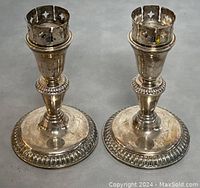 Pair of vintage BIRKS silver plated EP-brass Regency style candle holders displayed on flat surface, showing top crown section and base details.