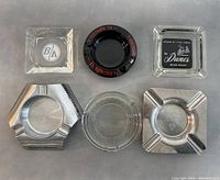 Top view of all six ashtrays in a flat layout, showing logos and shapes