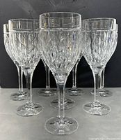 Front view of eight Ralph Lauren crystal wine glasses arranged in two rows with diamond-cut pattern visible.