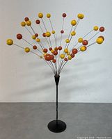 Front view of Danish vintage orange and black table mobile featuring yellow and orange spheres attached to thin metal rods on a black metal base.