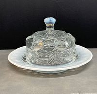 Side view of the covered butter dish showing the clear glass lid with Eye Winker Crystal pattern and opal milk glass base.