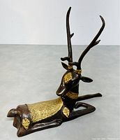 Front angled view of vintage metal deer figurine with brass decorated body and tall antlers