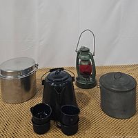 Photo showing all lot contents: enamel coffee pot, four cups, metal pail with lid, vintage red globe oil lantern