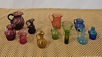 Full lot of 12 assorted depression glass pieces in different colors displayed on woven fabric surface