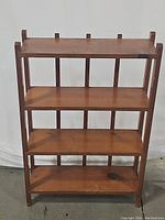 Front view of the wooden rack showing three shelves and spindle back uprights.