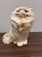 Front angle view of the ceramic cat figurine showing detailed fur and painted facial features