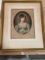 Full view of the framed antique art portrait of a woman in a green dress without glass