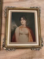 Framed painted portrait art with no glass, ornate antique frame with gilded decorations and matting, depicting a young woman in classical attire.