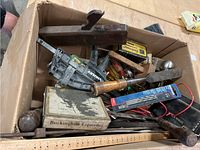 Image showing box containing manual wooden hand plane, saw blades, chisels, screwdrivers, pliers, and other small tools and accessories.