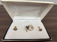 Photo of vintage jewelry set including a brooch and pair of stud earrings in a cream velvet lined box