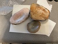 Three natural stone ashtrays on white paper showing polished surfaces and natural stone backs.