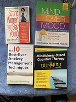 Photo showing four health-related self-help books arranged on a blue surface.