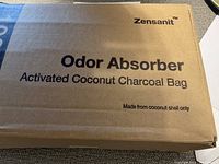 Close-up of cardboard packaging box with branding and product information of Zensanite Odor Absorber activated coconut charcoal bag