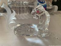 Left side view of clear Swarovski crystal seahorse figurine showing curled frosted tail and faceted body.