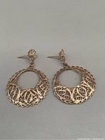 Front view of the pair of 10K gold filigree dangling earrings showing detailed open circular lace-like design.