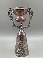 Full view of the marriage wager cup showing ornate figure holding the cup with silver plating and copper details.
