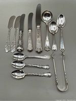 Overview of all 14 flatware pieces on grey background