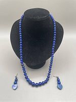 Full set displayed on black bust showing necklace and earrings positioned separately