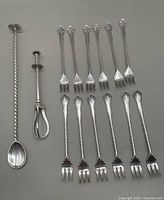 Lot includes 12 seafood forks, along with a twisted-handle muddler/bar spoon and a mechanical mechanical olive/sugar cube grabber.