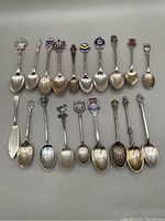 All 19 spoons laid out in two rows showing variety of finials and bowl shapes