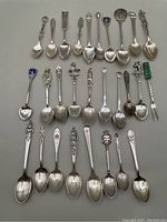 Overhead view of all 28 spoons arranged in rows on gray background