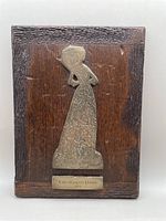 Full view of the wooden plaque with brass rubbing and nameplate visible